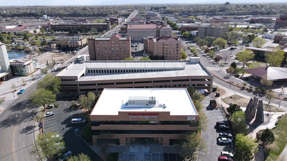 Aerial view of Vectra Bank building and downtown area with parking and cityscape.