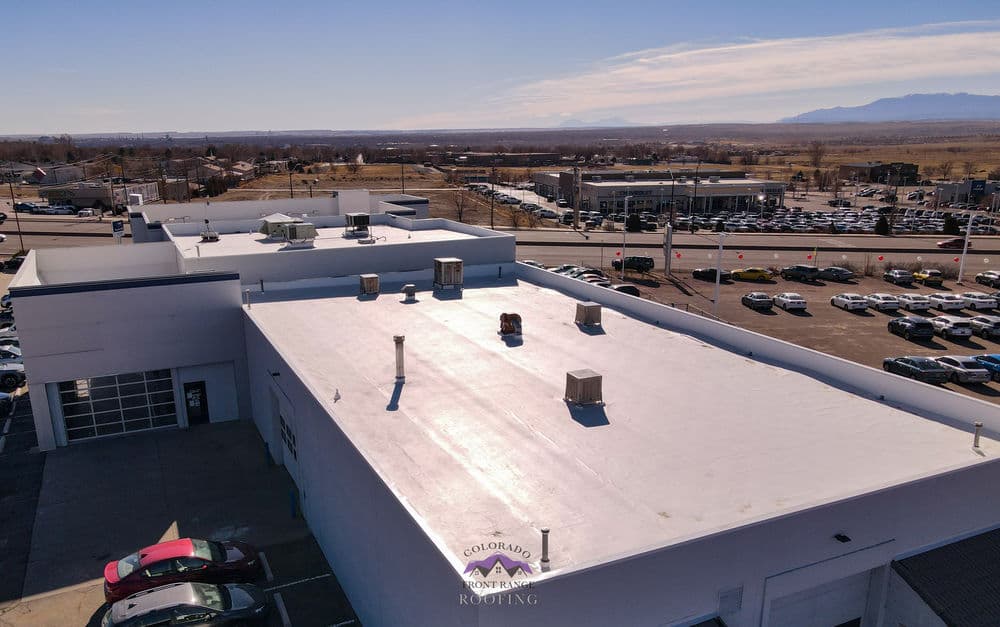 Aerial view of a commercial building with a flat roof and surrounding parking lots.